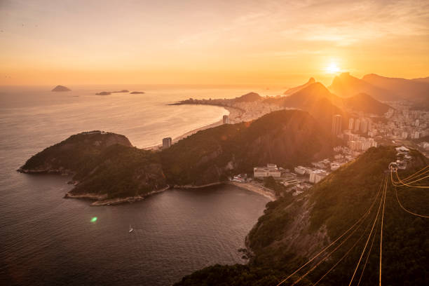 bellissima vista sul tramonto dorata dalla montagna sugar loaf alla funivia - urca rio de janeiro rainforest brazil foto e immagini stock