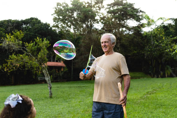 istock Grandfather making soap bubbles for granddaughter 1295893610