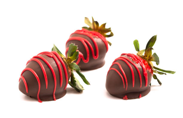 istock Chocolate Covered Strawberries with Red Drizzle Isolated on a White Background 1295896790