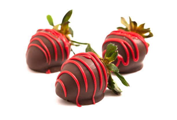 istock Chocolate Covered Strawberries with Red Drizzle Isolated on a White Background 1295896796