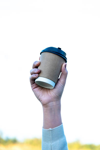 istock female hand holding a blank paper cup 1295896815