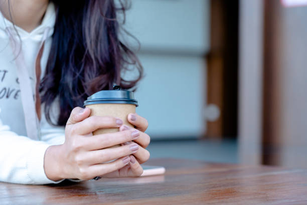 istock emale holding a  paper cup of coffee 1295896855