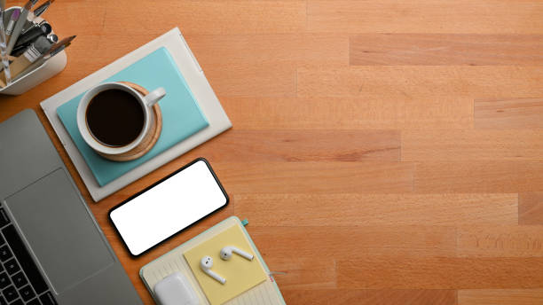 istock Workspace with smartphone, laptop, coffee cup, stationery and copy space on the table 1295896892