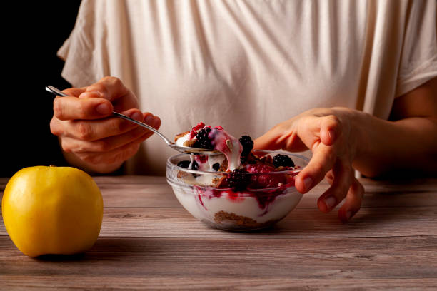 istock eating yogurt parfait with berries and an apple 1295896912