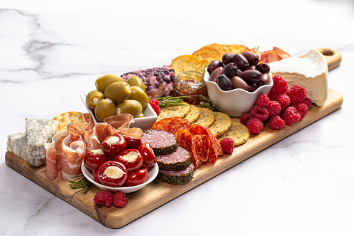 Savoury Charcuterie Board Covered in Meats Olives Peppers Berries and Cheese
