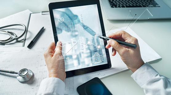 Doctor drawing healthcare business growth data graph .Medical examination and doctor analyzing medical report network connection on tablet screen in hospital.