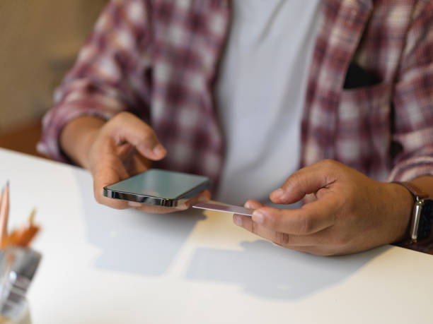 istock Businessman using smartphone on white table in office room 1295900304