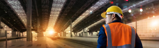 istock Back view of industrial engineer manager walking and checking structure and of construction railway of high speed on station background. Technology and engineering. transportation and logistics. 1295902083