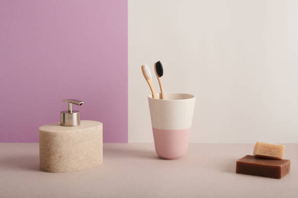 toma de bodegones de accesorios de baño de cerámica minimalista con cepillos de dientes y dos barras de jabón sobre fondo rosa y blanco, copiar espacio - bathroom item fotografías e imágenes de stock