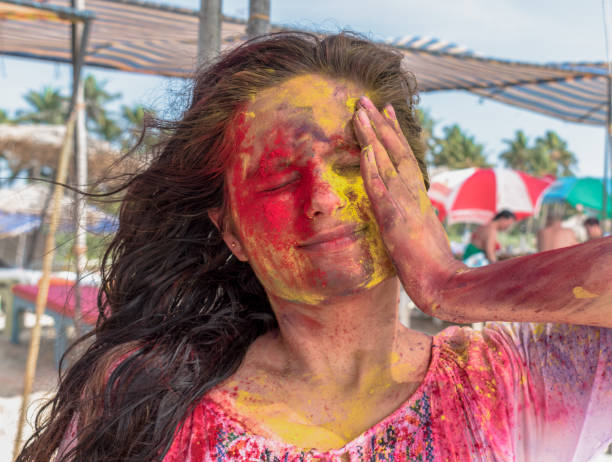 amazing candid photo of young girl playing and enjoying holi, festival of colors in india. applying vibrant shade of colors on her face by hand and closed eyes as she is taken by surprise. - colorful - facial expression child asia asian and indian ethnicities imagens e fotografias de stock