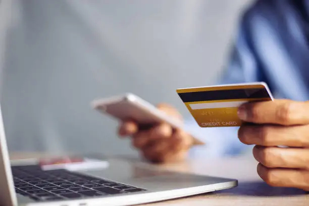 Photo of Online payment hands holding credit card and using laptop. Online shopping concept.