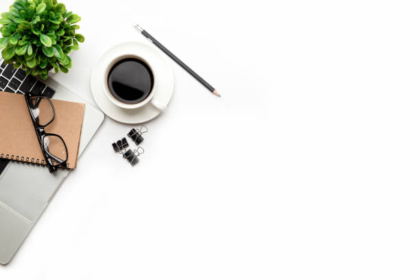 istock Flat lay, top view office table desk. Workspace with blank Laptop, office supplies, pencil, green leaf, and coffee cup on white background. 1295906416