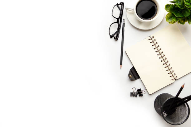 istock Flat lay, top view office table desk. Workspace with blank, office supplies, pencil, green leaf, and coffee cup on white background. 1295906424