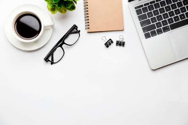 istock Flat lay, top view office table desk. Workspace with blank Laptop, office supplies, pencil, green leaf, and coffee cup on white background. 1295906441