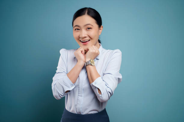 istock Asian woman happy surprised isolated on blue background. 1295908948