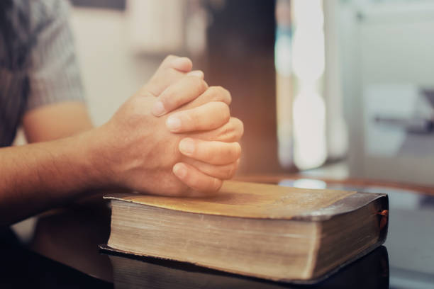 istock a man prays on the holy bible 1295909869