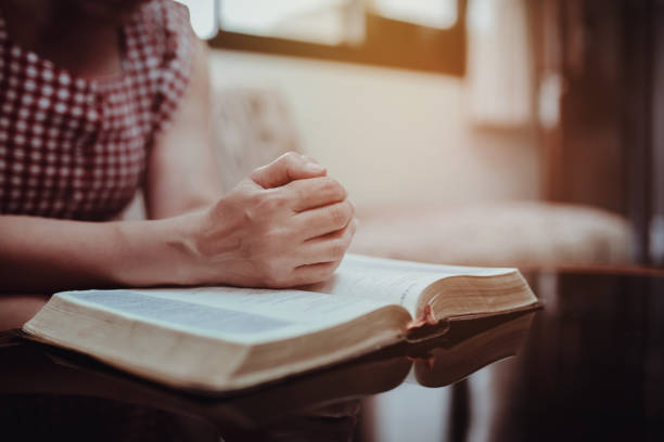 istock a woman prays on the holy bible 1295909898
