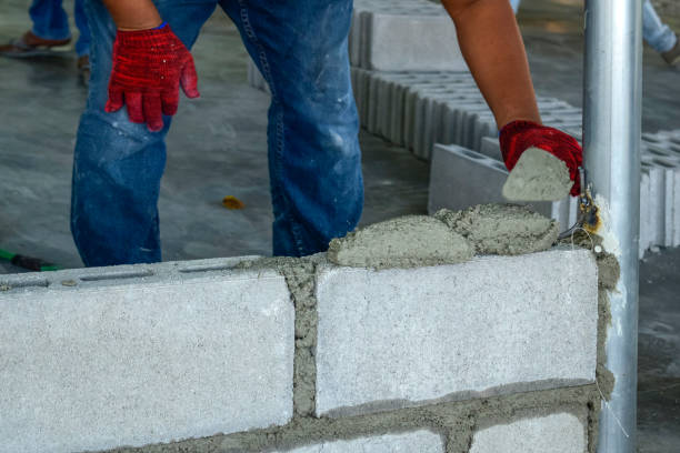 istock Plaster worker wearing red gloves is laying bricks. 1295910637