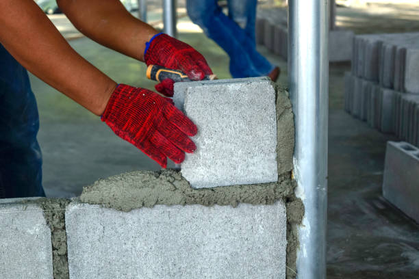 istock Plaster worker wearing red gloves is laying bricks. 1295910750