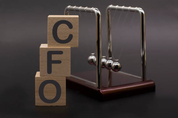 text CFO Chief Financial Officer on vertical row of wooden blocks text CFO - Chief Financial Officer on vertical row of wooden blocks and Newton's cradle . Business concept. cfo stock pictures, royalty-free photos & images