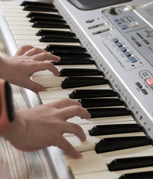 istock The hands of caucasian unrecognizable boy are playing old synthesizer. 1295915856