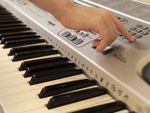 istock The hands of caucasian unrecognizable boy are playing old synthesizer. 1295915875
