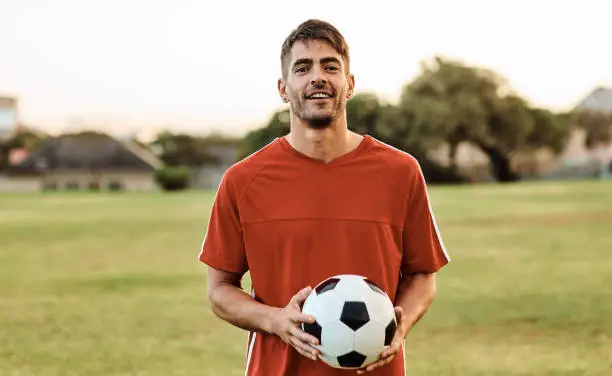 Shot of a soccer player holding a ball while out on the field