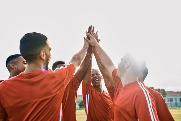 Let's show them! Shot of a team of soccer players giving each other a high-five after their match high five soccer stock pictures, royalty-free photos & images