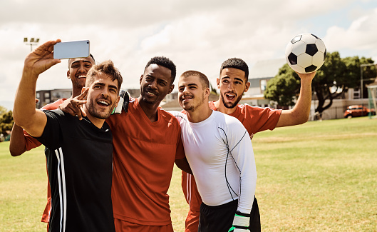 Shot of young soccer players taking a selfie while standing together on the field