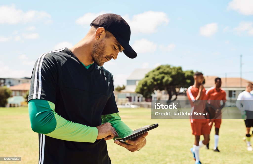 My team is doing very good Shot of a soccer coach using a digital tablet while out on the field Coach Stock Photo