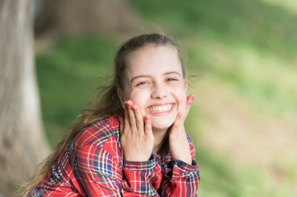 un sorriso sano inizia con un bambino. bambino sorridente con un sorriso bianco sano su una bella faccia. bambino piccolo carino con lunghi capelli biondi e sorriso felice. adorabile bambina con un grande sorriso - toothy smile relaxation white healthcare and medicine foto e immagini stock