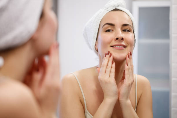 istock Woman looking herself in mirror 1295917902