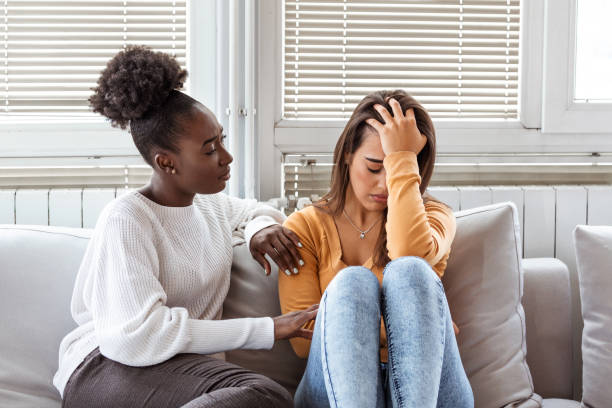 fille triste et amis de soutien essayant de résoudre un problème. deux femmes diverses tristes parlant à la maison. amis féminins soutenant l’un l’autre. problèmes, concept d’amitié et de soins - child grief mourner disappointment photos et images de collection