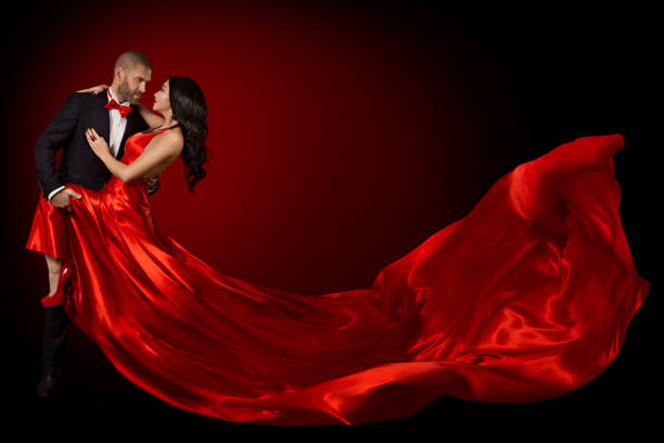happy dancing para portret, kobieta w czerwonej jedwabnej sukni i przystojny broda mężczyzna w garniturze, latające machanie tkaniny - passion kissing black white zdjęcia i obrazy z banku zdjęć