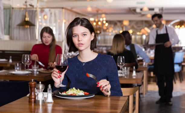 istock Happy girl alone in restaurant 1295923691