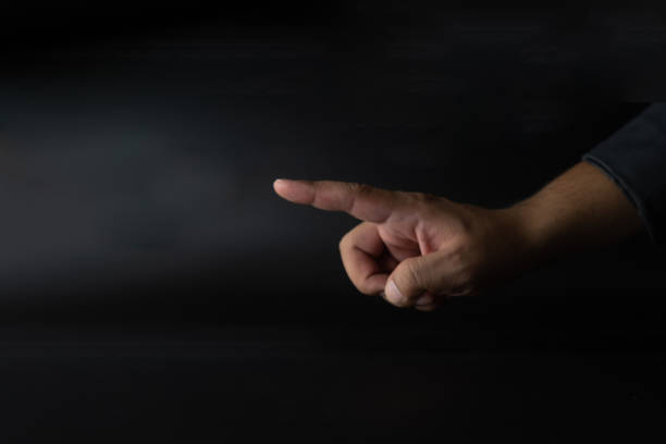 istock Empty businessman in suit pointing finger on black dark background 1295924941