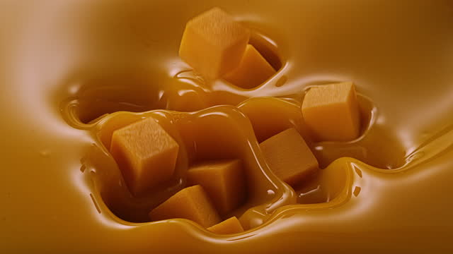 caramel cubes splashing into caramel ice cream mixture