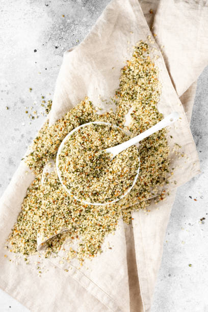 hemp seeds. peeled whole dried hemp seeds in a white ceramic bowl on a light gray kitchen table. hemp seeds for cooking - hemp seed heap white imagens e fotografias de stock