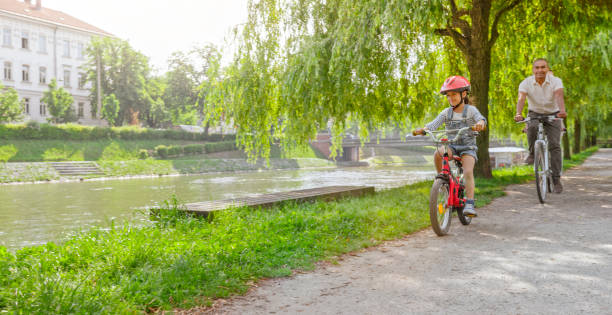 istock Father and daughter riding bicycle 1295928675
