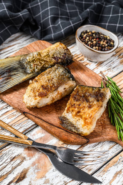 istock Baked sliced silver carp. Wooden background. Top view 1295929922
