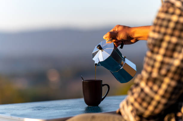 istock A man holding a coffee cup, the scene in front is a mountain 1295929948