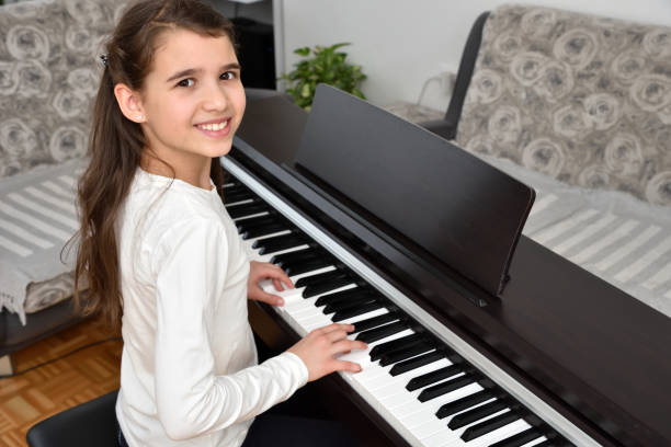 Young girl playing the piano Child practicing on the modern electric piano at home. Music lesson. girl playing piano stock pictures, royalty-free photos & images