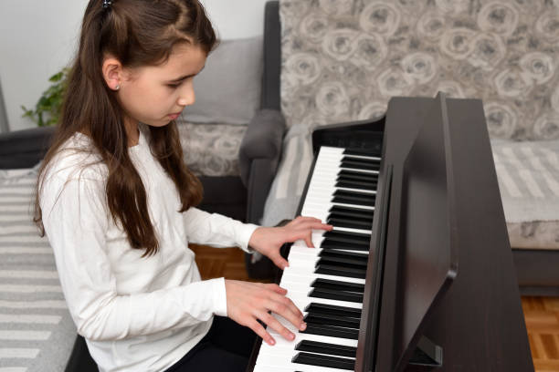 istock Young girl playing the piano 1295931402