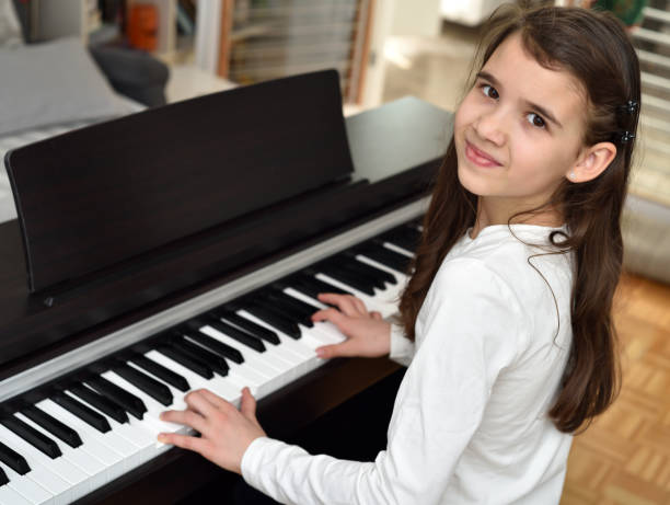 istock Young girl playing the piano 1295931461
