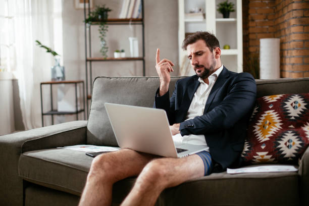 istock Businessman working online, wearing suit and no pants. Y 1295932905