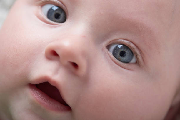 istock cute little baby playing with hands and smiling 1295933827