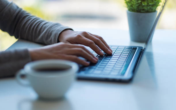 istock a woman working and typing on laptop computer keyboard with coffee cup on the table 1295933881