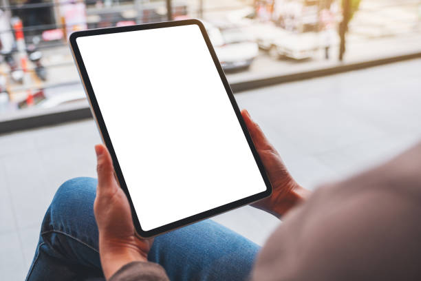 istock a woman holding digital tablet with blank white desktop screen 1295933886