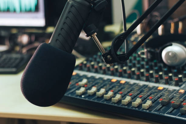 istock Radio host microphone, mixing console and headphones close-up 1295934156