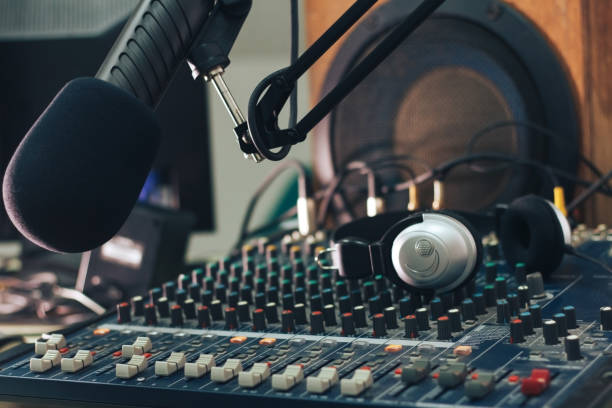 istock Radio host microphone, mixing console and headphones close-up 1295934162